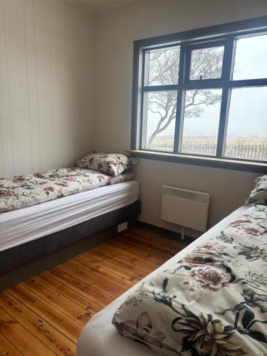 a bedroom with two beds and a window at Grjótá Historical countryhouse in Hvolsvöllur