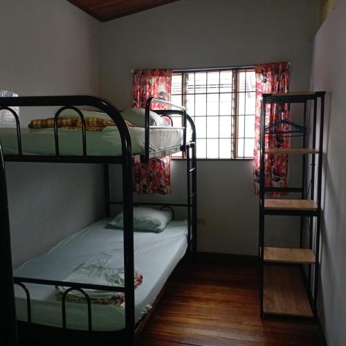 a room with two bunk beds and a window at Hostel Casa Ridgway in San José