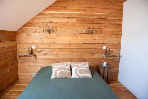 a bedroom with wooden walls and a bed with two pillows at Une demeure d'exception au cœur des Alpes du Sud in Venterol