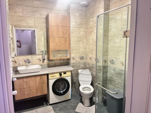 a bathroom with a toilet and a sink and a shower at kobuleti Apartment in Kobuleti