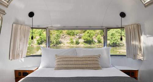 a bed in a room with a large window at AutoCamp Asheville in Asheville