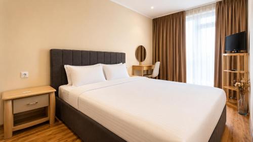 a bedroom with a large bed and a window at Boris Garden Comfort Suite in Burgas