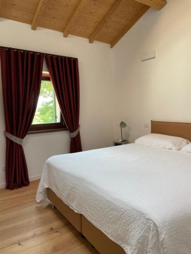 a bedroom with a large bed and a window at Il Rustico di Corte Palù in San Martino Buon Albergo
