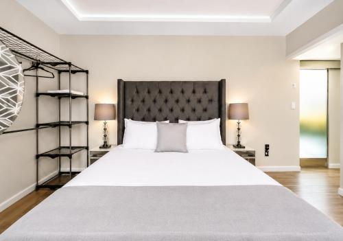 a bedroom with a large white bed and two lamps at Árbol Suites in Tijuana