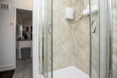 a shower with a glass door in a bathroom at 2Bd Mid Terrace Close To Station in Stoke on Trent