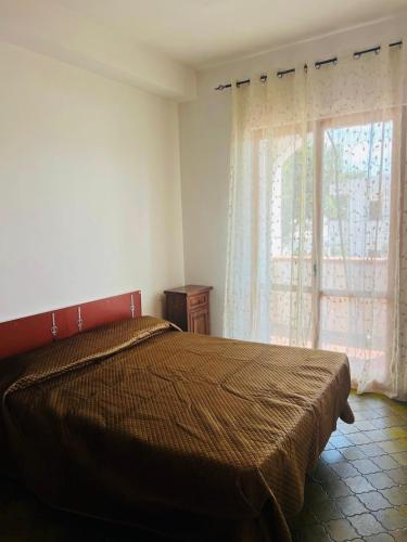 a bedroom with a bed with a large window at Lido del Sole bilo 28 in Rodi Garganico