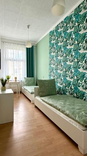 a living room with two couches and a blue wall at Beautiful Rooms - Park Kasprowicza in Szczecin