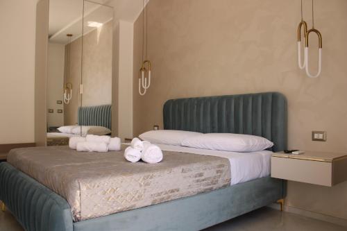 a bedroom with a large bed with towels on it at Aurea Rooms in Porto Cesareo