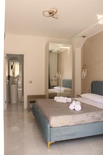 a bedroom with two beds and a large mirror at Aurea Rooms in Porto Cesareo