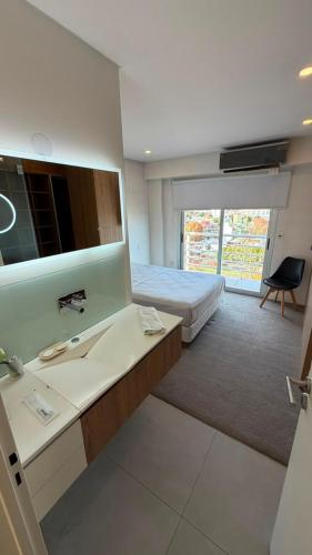 a bedroom with a bed and a sink and a mirror at Duplex Premium Ciudad Jardín in El Palomar