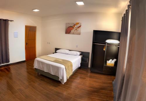 a bedroom with a bed and a wooden floor at Nosso Hotel Extrema - recém inaugurado in Extrema