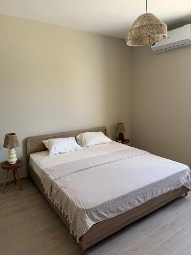a bedroom with a large bed with white sheets at D bay north coast chalet in El Dab‘a