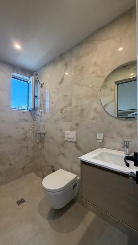 a bathroom with a toilet and a sink and a mirror at Villa MarJon in Vlorë