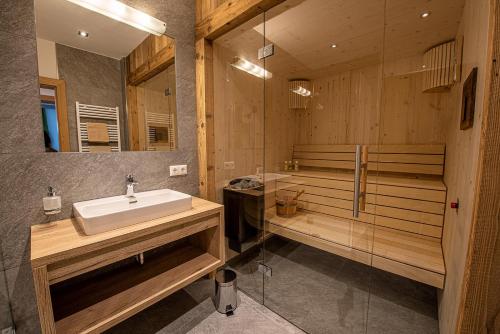a bathroom with a sink and a bath tub at AppartMO 243 Top 1 in Krimml