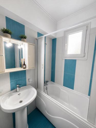 a white bathroom with a sink and a tub and a sink at My Chios Apartments in Chios