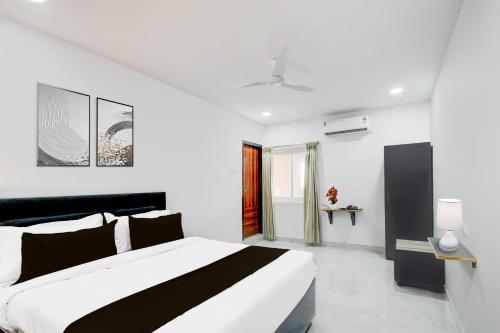 a white bedroom with a black and white bed at Super Townhouse B N Reddy Formerly Capitol Stay Inn in Surūrnagar