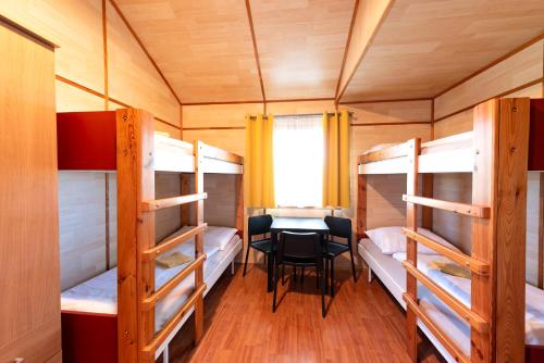 a room with bunk beds and a table and chairs at CAMP VARY - Vítkova Hora in Karlovy Vary