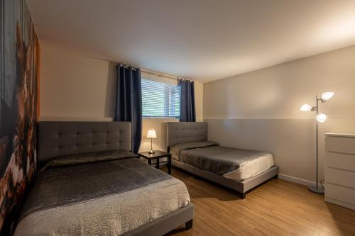 a bedroom with two beds and a window at EdenCat Condo - Mountain View in Beaupré