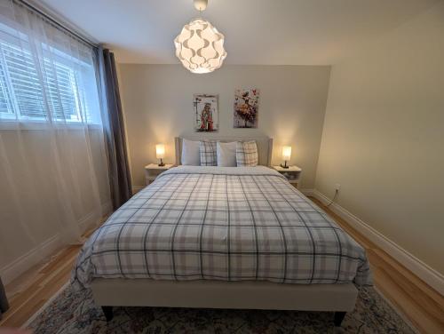 a bedroom with a bed and a chandelier at Modern, private & luxurious executive suite in Delta