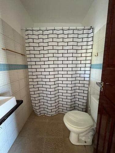 ein Badezimmer mit Toilette und einer Ziegelwand in der Unterkunft Wind Life in Itarema