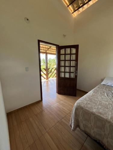 ein Schlafzimmer mit einem Bett und einer offenen Tür in der Unterkunft Wind Life in Itarema