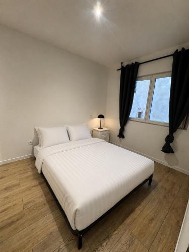 a large white bed in a room with a window at Les Perles de Limoux - Centre Clim Wifi Parking Gratuit in Limoux