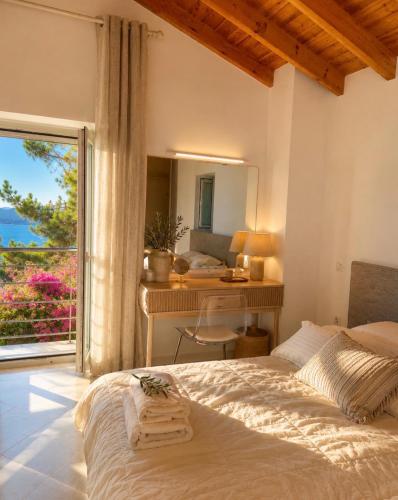a bedroom with a bed and a desk and a window at Villa Armando Corfu Jacuzzi in Perama