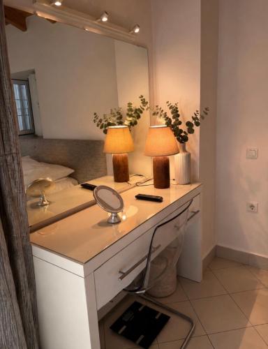 a bathroom with a vanity with two lamps and a mirror at Villa Armando Corfu Jacuzzi in Perama