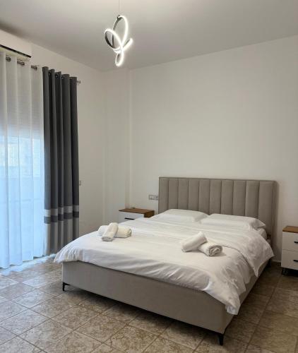 a bedroom with a large bed with a ceiling fan at Fusha Apartment in Velipojë
