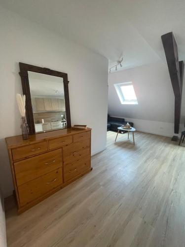 a living room with a dresser and a mirror at Le 3eme Mistral in Molsheim