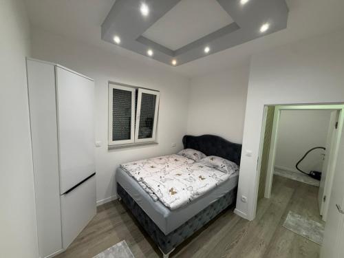 a white bedroom with a bed and a window at Villa Lux Una in Bosanska Krupa