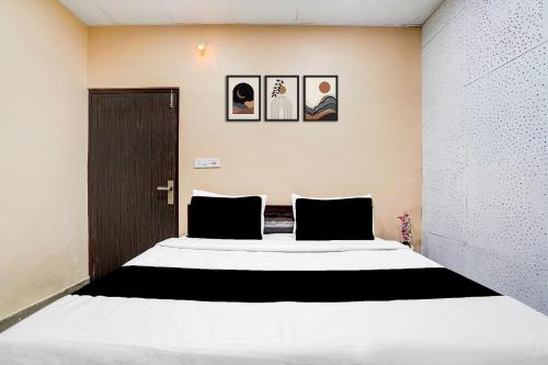 ein Schlafzimmer mit einem großen Bett mit schwarz-weißer Bettwäsche in der Unterkunft Collection O by OYO Burlton Park Jalandhar Formerly Hotel R1 Inn in Jalandhar