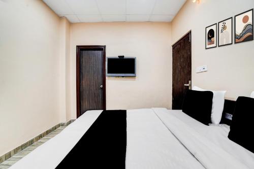 ein Hotelzimmer mit Bett und Fernseher in der Unterkunft Collection O by OYO Burlton Park Jalandhar Formerly Hotel R1 Inn in Jalandhar