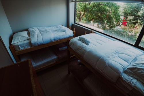 a small room with a bed and a window at HoTELBLU in Santiago