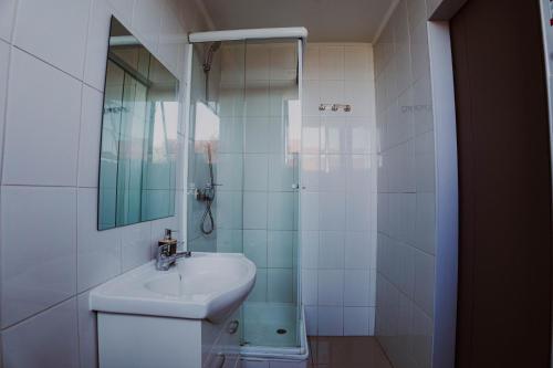 a bathroom with a sink and a shower with a mirror at HoTELBLU in Santiago