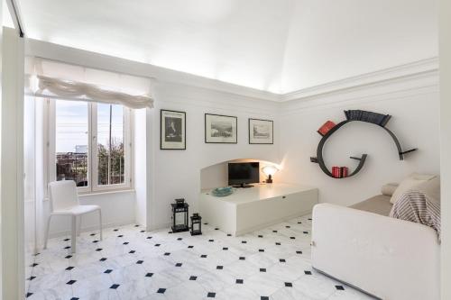 a white living room with a couch and a table at Bright Sea View Home, Steps from the Beach in Lavagna