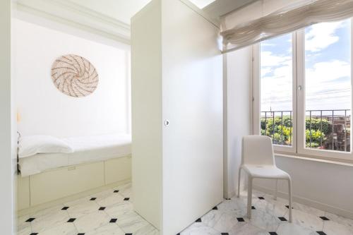 a white room with a chair and a window at Bright Sea View Home, Steps from the Beach in Lavagna
