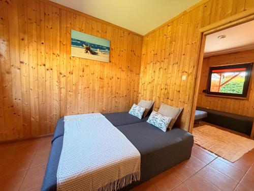 a bedroom with a bed in a wooden wall at ZEFIR Dąbki in Dąbki