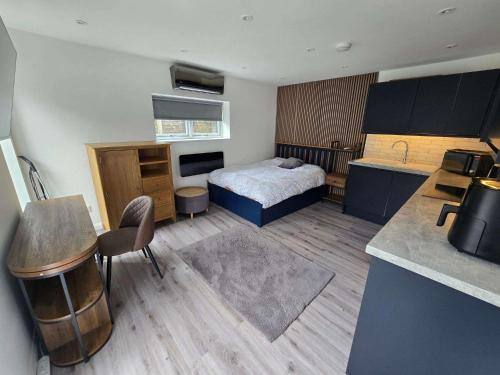 a bedroom with a bed and a kitchen with a sink at The Out House in Hemel Hempstead