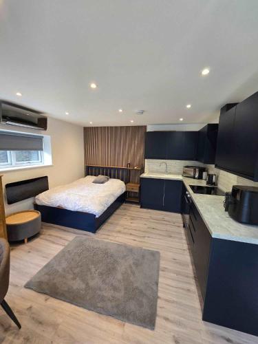 a large bedroom with a bed and a kitchen at The Out House in Hemel Hempstead