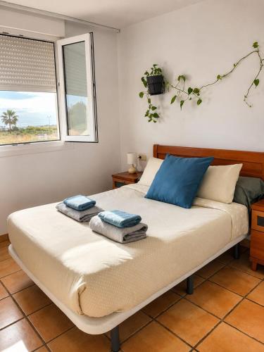 a bedroom with a bed with blue pillows and a window at Golf Paradise in Sant Jordi