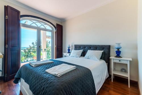a bedroom with a bed with a large window at Bela Vista in Azambuja
