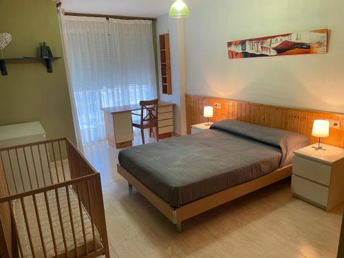 a bedroom with a bed and a table and a desk at Apartamento en el Edificio Barlovento, situado en el centro de Alcossebre, a 150m del mar in Alcossebre