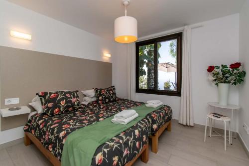 a bedroom with a bed and a window at Infinity House. Ocean View hot tub. in Adeje