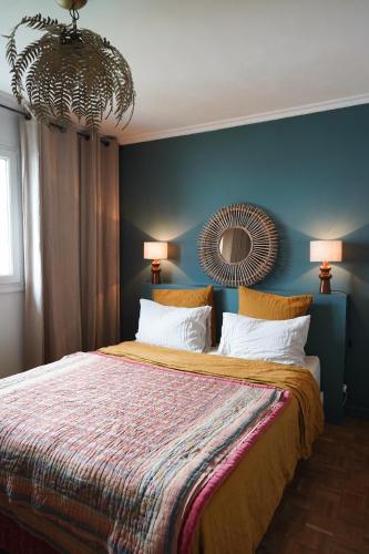 a bedroom with a large bed with a blue wall at Chambre confortable Piscine Maison EtxeCosy in Bidart