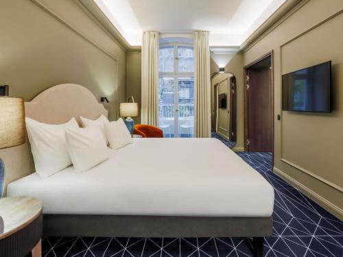 a hotel room with a bed and a television at Movenpick Hotel Tallinn in Tallinn