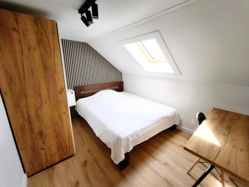 a small bedroom with a bed and a skylight at Willa Sunny Garden in Sint-Laureins