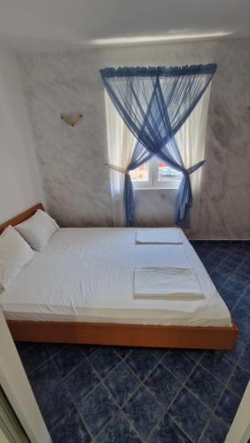 a bed in a room with a window at Apartmani MULIC Sutomore in Sutomore