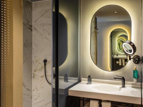 a bathroom with a sink and a mirror at Novotel México City Centro Histórico in Mexico City