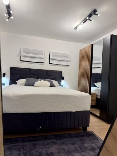 a bedroom with a large bed and a mirror at A-Frame Villa - Kovačević Hills in Velika Kladuša